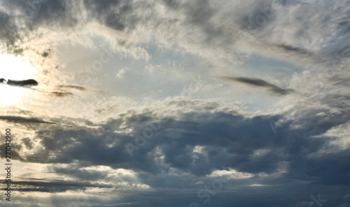 Beautiful sunset sky background with clouds and sunbeams