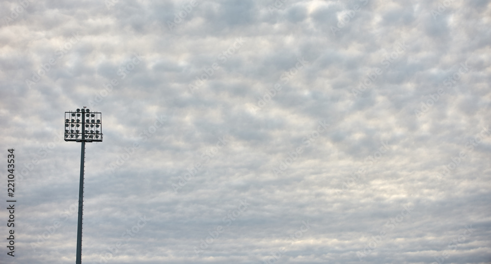 Two stadium lights under cloudy sky, background with copy cpace Two stadium lights under cloudy sky, background with copy cpace