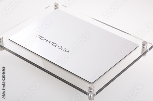 STOMATOLOGIA - Plastic blank with text on white background. Silver color. photo