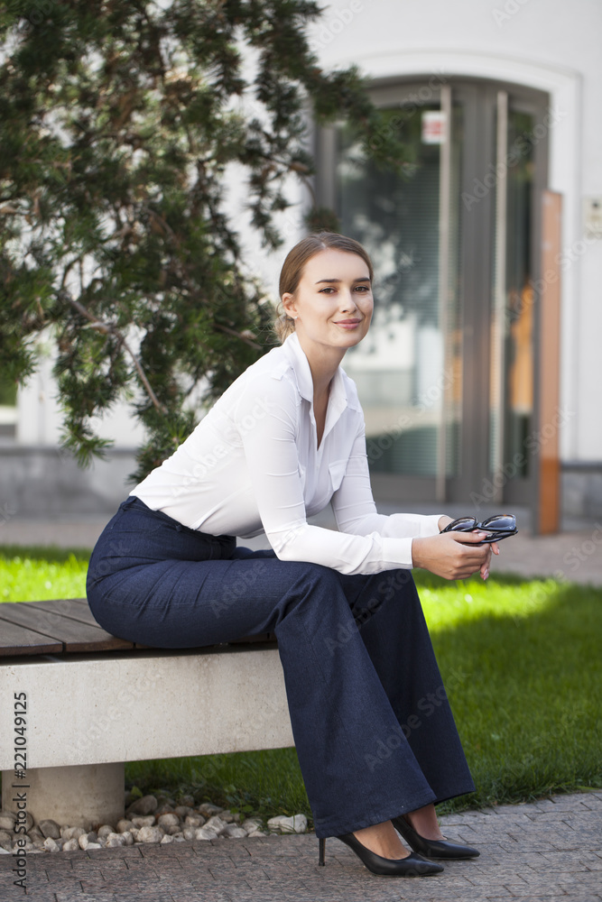Young woman sitting on bench in the street Young woman sitting on bench in the street