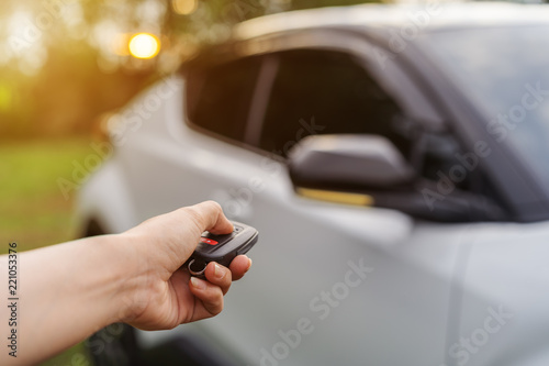 hand using remote key to unlocked car