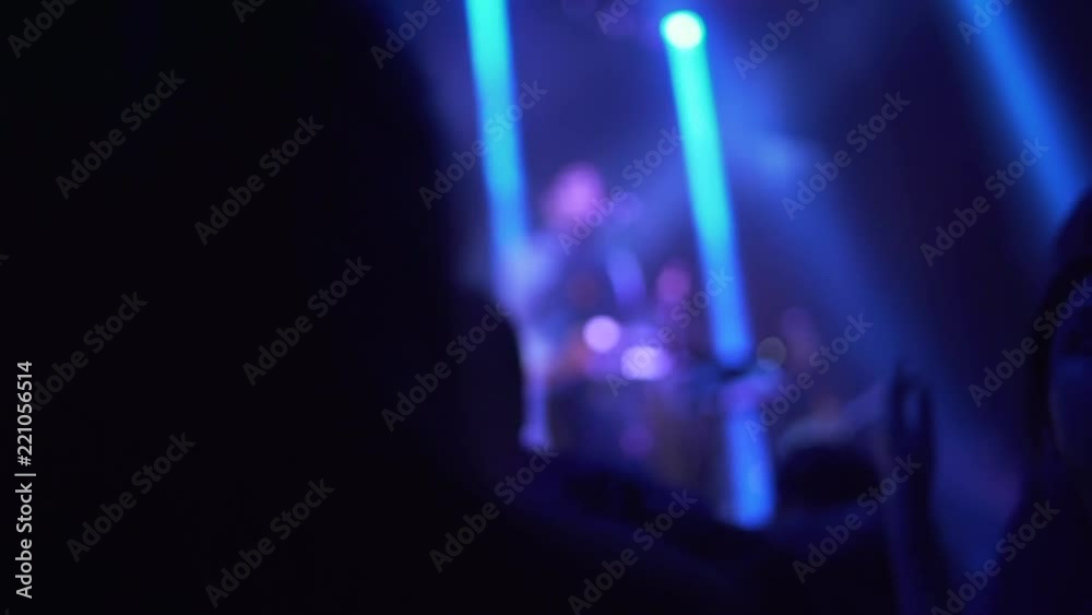 Silueta de mujer en el público danzando en concierto.