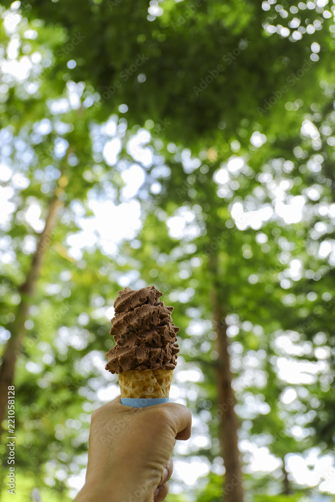 ice cream in hand with the green tree background ice cream in hand with the green tree background
