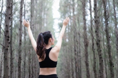 Female is stretching before exercise in the park on the morning.Young woman warming up in the park. photo