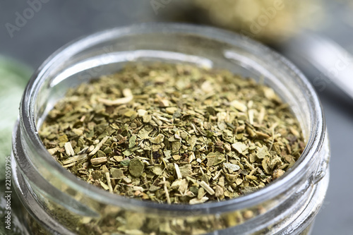 Dried leaves of yerba mate tea, a traditional tea in South-America, photographed in glass jar on slate (Selective Focus, Focus one third into the tea leaves) photo