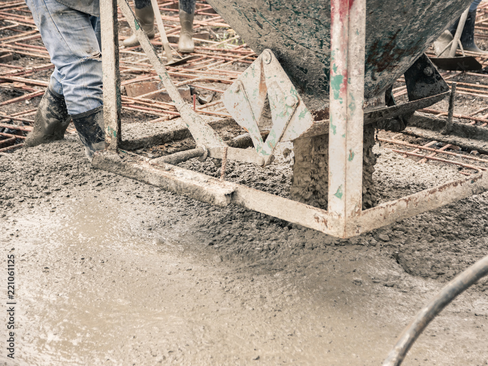 Pouring ready-mixed concrete from mixing mobile the concrete mixer into basket steel to lift the concrete to the point of inaccessibility.