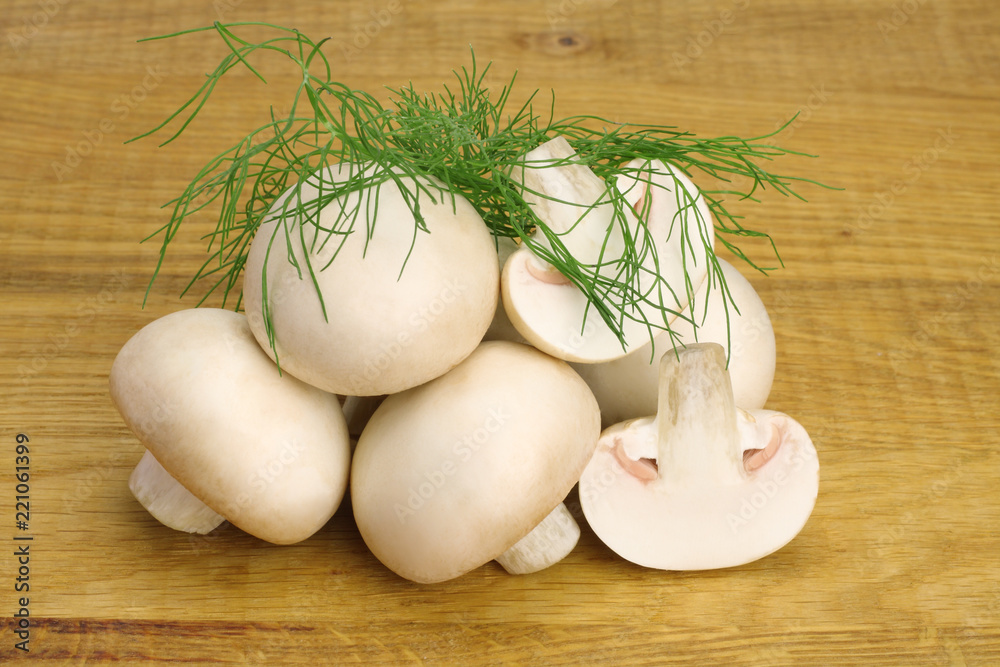 Mushrooms with dill leaves isolated on a wooden background Mushrooms with dill leaves isolated on a wooden background