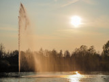 Beautiful view of a fountain in a public park at sunset in backlight