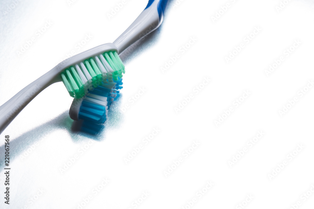 Blue and green toothbrush on a shiny gray background Blue and green toothbrush on a shiny gray background