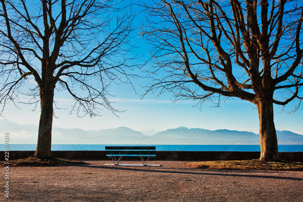 Bench by the lake, calm and relaxing morning on the shores of Lake Geneva, popular travel destination in Switzerland