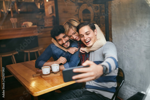 Friends Taking Photos On Phone In Cafe. Video Call