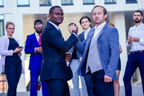 Multiracial african and caucasian men handshaking at meeting and making deal shaking hands to white businessman multinational and multiethnic corporate business people . Greeting Deal Concept