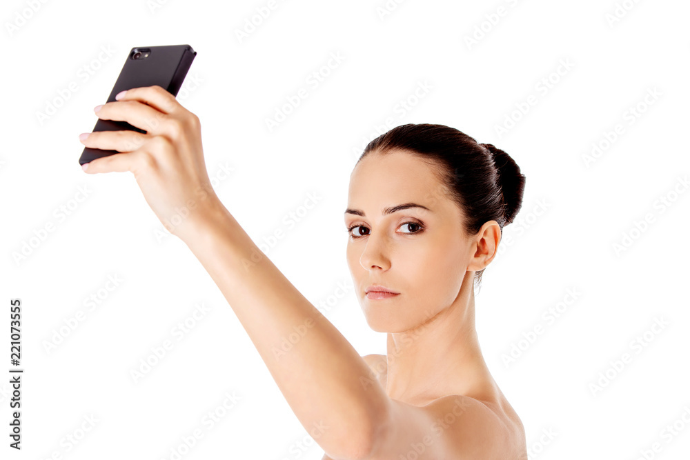 Nude beautiful woman taking selfie on white background. Nude beautiful woman taking selfie on white background.