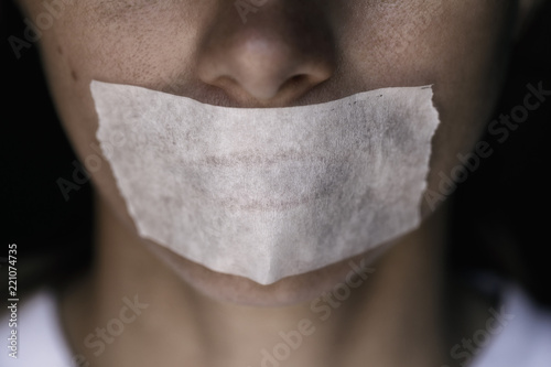 Censorship in the Modern World: A man's mouth sealed with an adhesive tape, close-up photo
