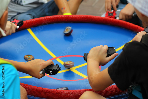 Boys playing popular game beyblade with special spinning tops at the central park. photo