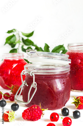 homemade jam in a glass jar of various berries and plums on a light background.Healthy food, diet, detox, clean eating and vegetarian concept with copy space.