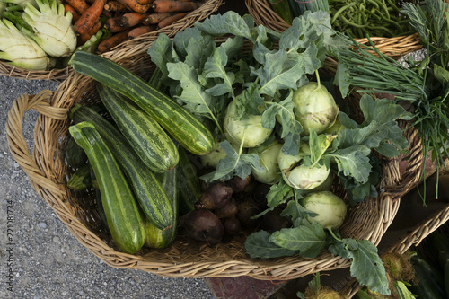 Korb mit Zucchini und Kohlrabi vor dem Laden