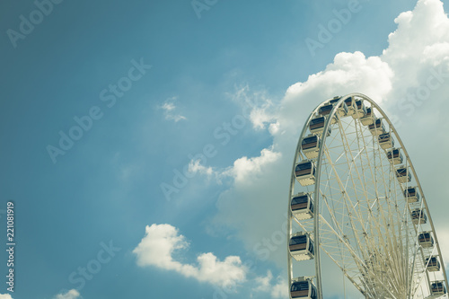 Vintage White big Ferris wheel with blue sky sharp clouds