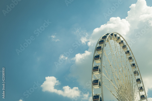 Vintage White big Ferris wheel with blue sky sharp clouds