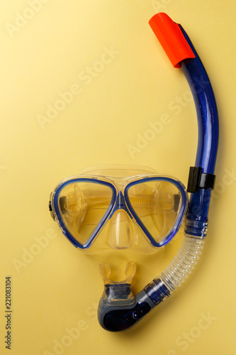 Diving equipment. Snorkeling mask and tube on yellow background. Colorful background. Top view. Copy space. Flat lay