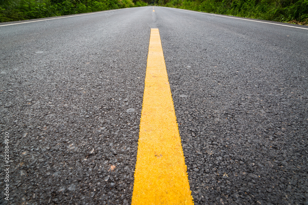 Empty asphalt road through the agricultural fields