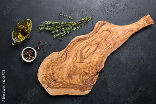 Olive wood cutting board, spices and herbs for cooking. Food background with copy space for text, recipe, greeting, advertising photo