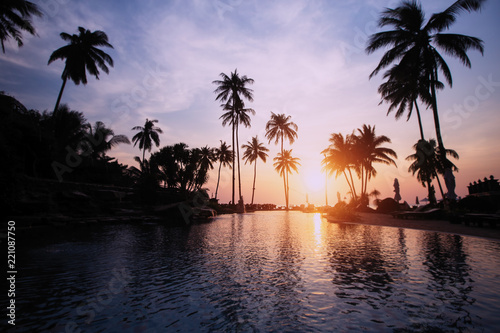 Beautiful sunset with silhouettes of palm trees on a tropical beach.