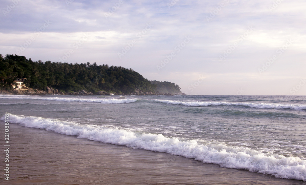 Beautiful sunset on Karon beach. The surf pounds the shore. Phuket, Thailand