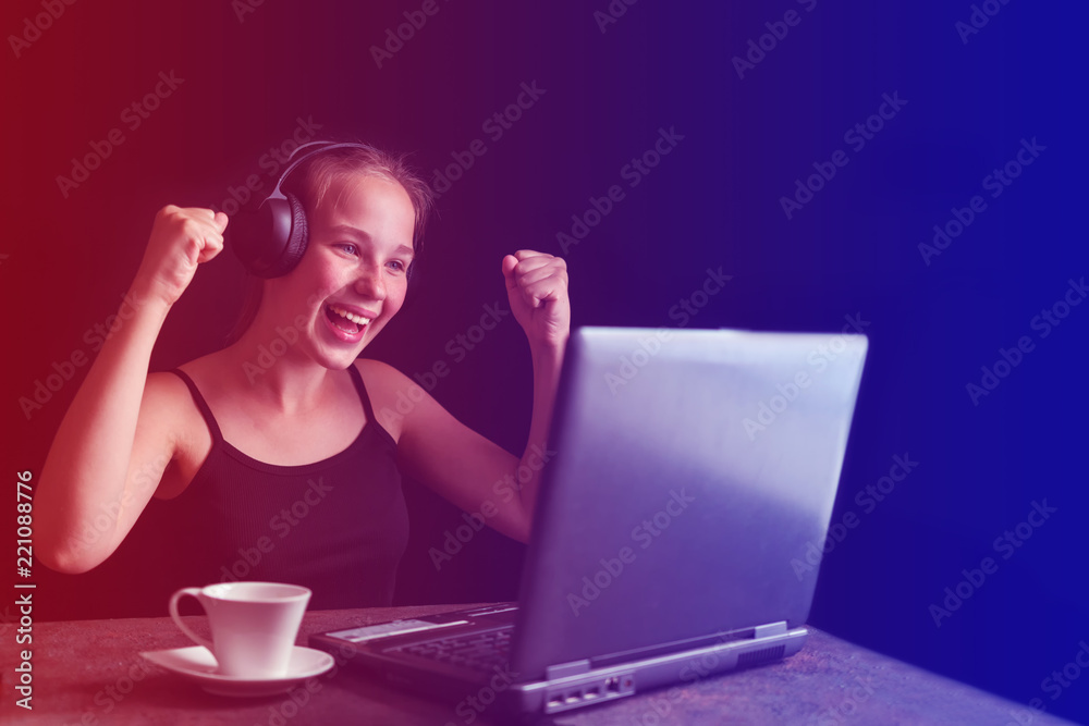 Girl teenager in playing a computer game on a dark background with copy space selective focus, concept of technology and video games Girl teenager in playing a computer game on a dark background with copy space selective focus, concept of technology and video games