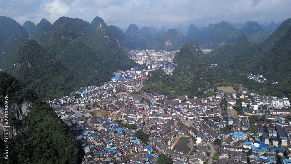 aerial view of town between green hills in Indonesia aerial view of town between green hills in Indonesia