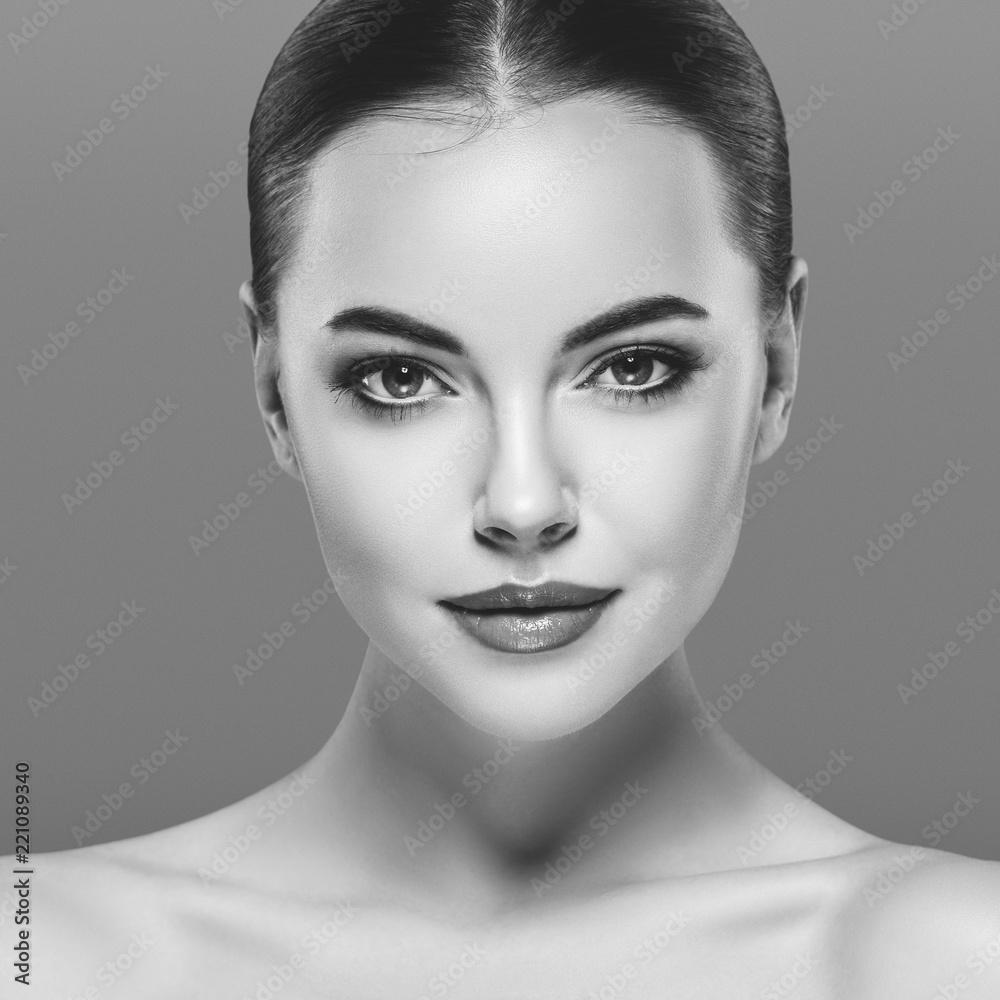 Female hairstyle long and cuerly black and white portrait over gray background Female hairstyle long and cuerly black and white portrait over gray background