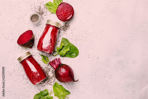 Delicious beetroot smoothies in glass bottles with chia on white food background, top view