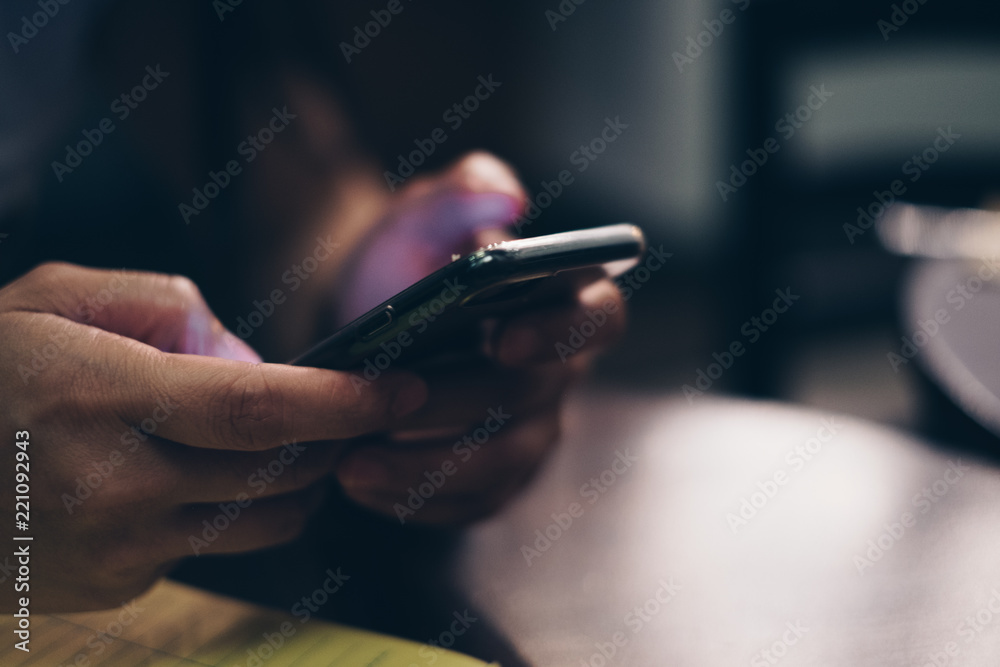 Lady's hand holding a cellphone. Selective focus. Copy space. Lady's hand holding a cellphone. Selective focus. Copy space.