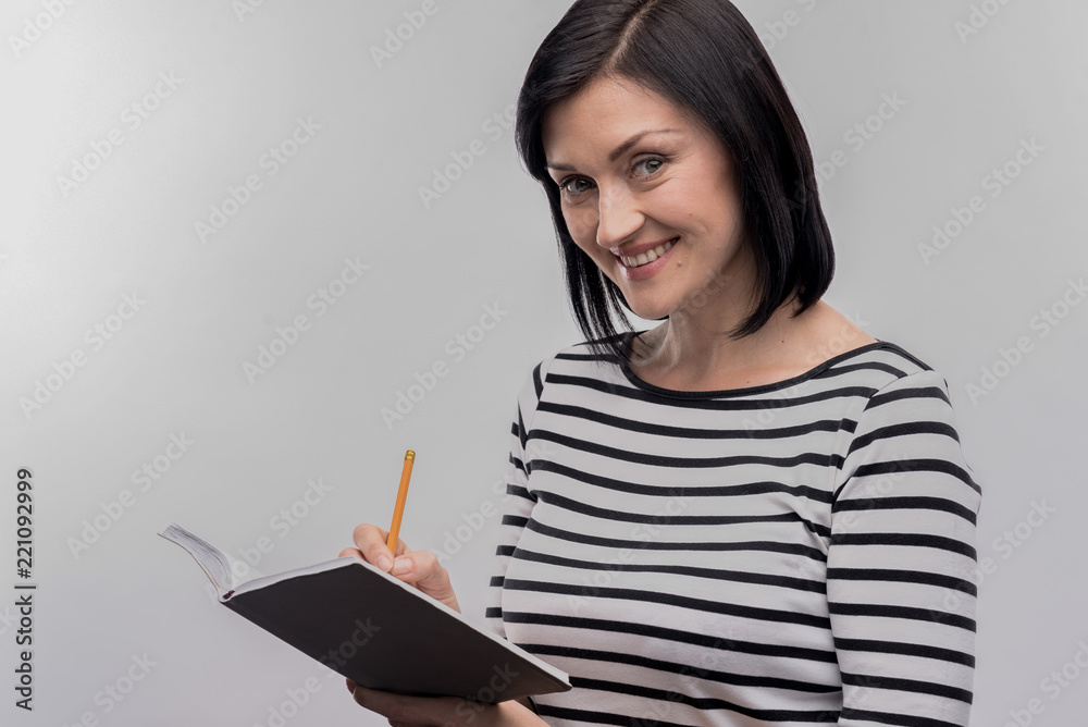 Green-eyed woman. Image without face retouching with green-eyed woman with facial wrinkles holding notebook and pencil Green-eyed woman. Image without face retouching with green-eyed woman with facial wrinkles holding notebook and pencil