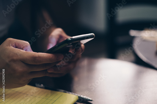 Lady's hand holding a cellphone. Selective focus. Copy space. photo