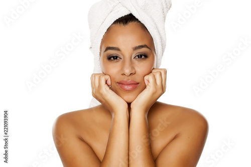 portrait of young beautiful dark-skinned woman with towel on her head, posing on a white background