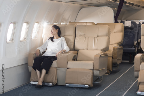 Elegant mature woman relaxing on airplane photo