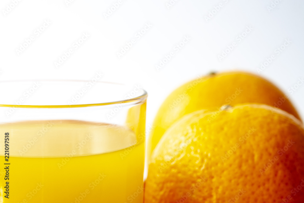 Glass of juice with two oranges isolated over white background. Close up photo, shallow dof. Glass of juice with two oranges isolated over white background. Close up photo, shallow dof.