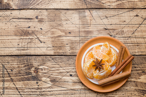 Christmas concept. tangerines and cinnamon sticks with anise and nuts on wooden background.