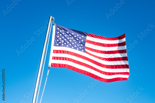 USA Flag isolated against blue sky blowing in the wind