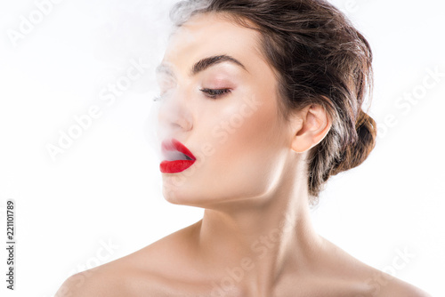 beautiful fashionable woman blowing smoke, isolated on white