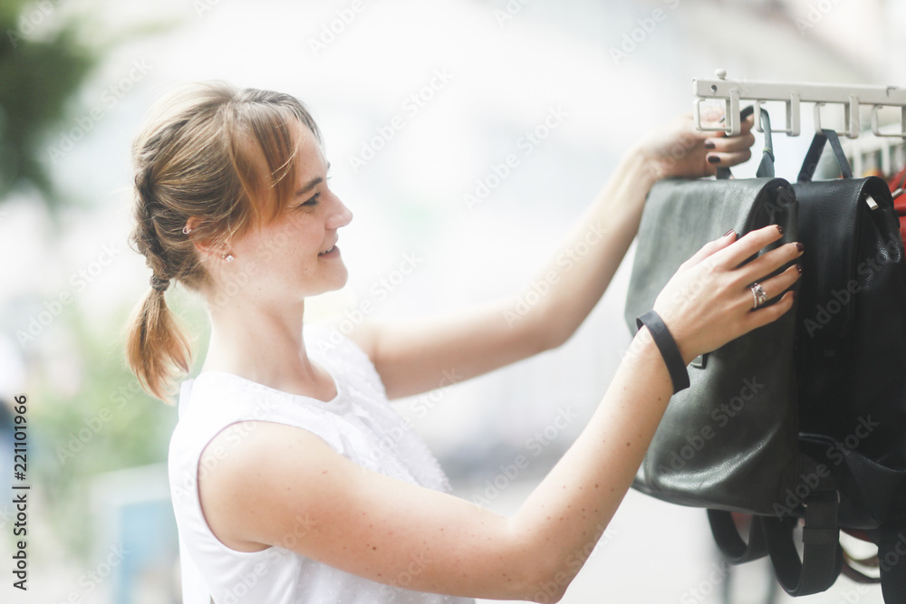 Obraz premium Junge Frau kauft Tasche