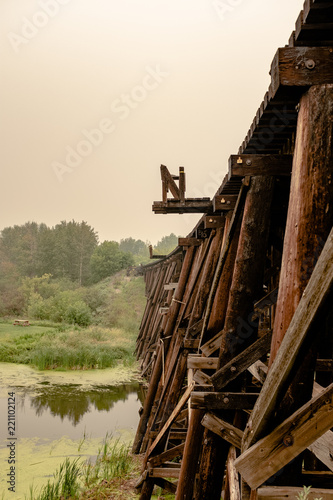 old wooden train bridge curving over water