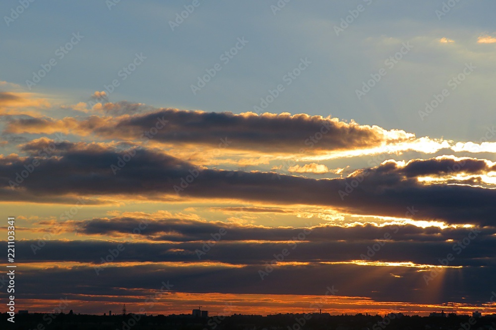 Beautiful dark clouds in the sky at golden sunset, natural background 