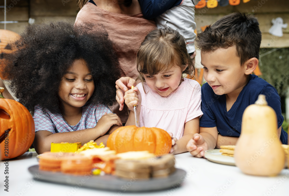 Young kids carving Halloween jack-o'-lanterns Young kids carving Halloween jack-o'-lanterns