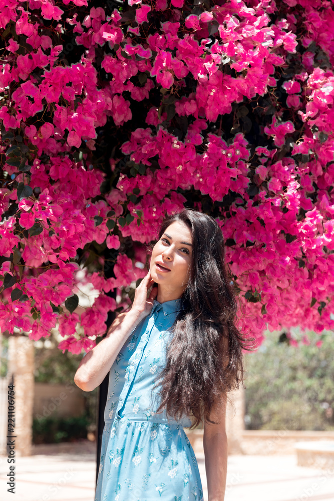 portrait of a brunette girl in flowers on a summer day in a blue dress portrait of a brunette girl in flowers on a summer day in a blue dress