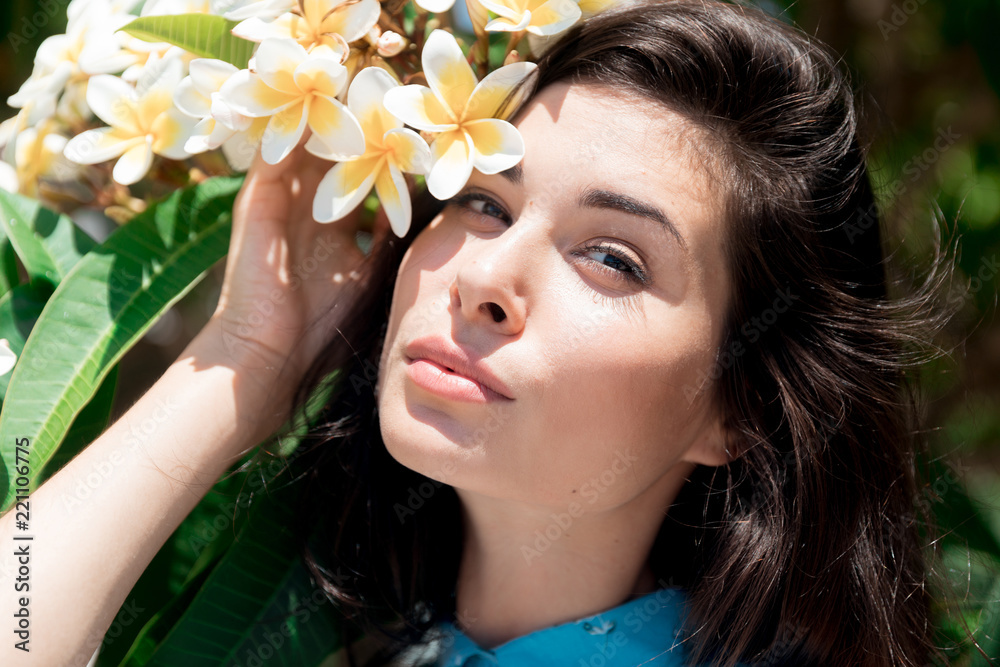 portrait of a brunette girl in flowers on a summer day in a blue dress portrait of a brunette girl in flowers on a summer day in a blue dress