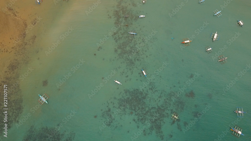 Fototapeta premium Aerial view of sailing boats and yachts in the bay. Boat and yacht in the tropical lagoon. Aerial view: tropical landscape. Philippines, El Nido. Travel concept.
