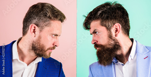 Business competition and confrontation. Business partners competitors or office colleagues in suits with tense bearded faces close up. Hostile or argumentative situation between opposing colleagues