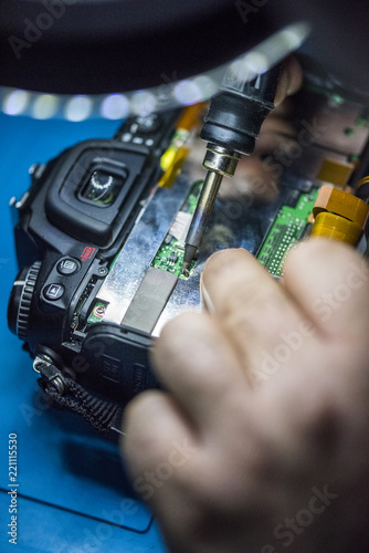 man hands reparing a photo camera. welding photo